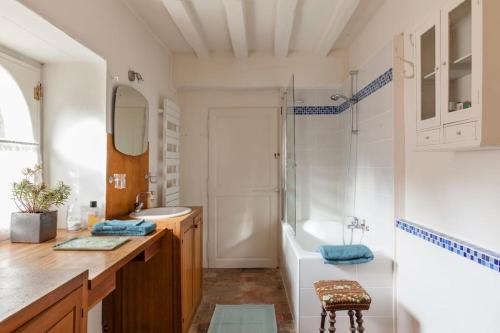 een badkamer met een bad, een wastafel en een douche bij Charming Normandy Country Home in Condeau