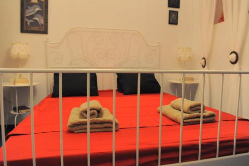 a bed with towels on it with a red sheet at Dandy Villas Velanidia Sailor's House - Private Maisonette - Sea View in Velanídhia