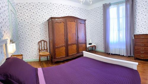 um quarto com uma cama roxa e um armário de madeira em Biarritz-Anglet Appartement T3 en villa jumelle em Anglet