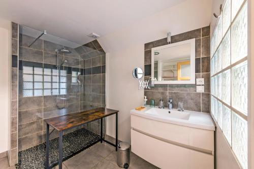 ein Bad mit einem Waschbecken, einer Dusche und einem Spiegel in der Unterkunft Gîte Orloucie au coeur des Abers proche de tout in Lannilis