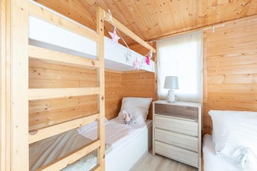 a bedroom with bunk beds in a wooden house at Domki Marina Rowy in Rowy