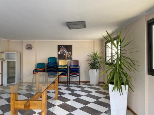 Un comedor con una mesa de cristal y sillas. en Edificio Manantiales, en Villa Carlos Paz