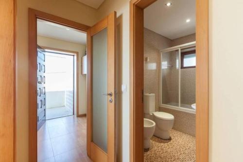 a bathroom with a toilet and a tub and a sink at Casa do Mar em Moledo in Moledo
