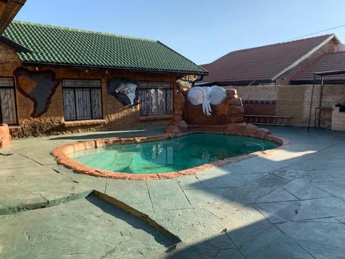 a house with a swimming pool in the yard at Sikhula Sonke Guest House in Erasmus