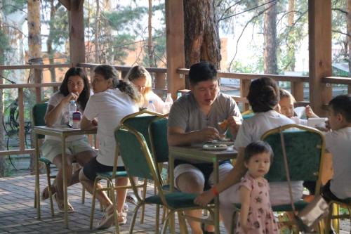 grupa ludzi siedzących przy stole w obiekcie Orman Ski w mieście Shchuchinskiy