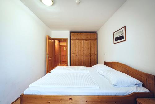 a bedroom with a large bed with a wooden frame at Pohorje Village Wellbeing Resort - Family Apartments Bolfenk in Pohorje