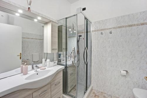 a bathroom with a glass shower and a sink at Serendipity in Alassio