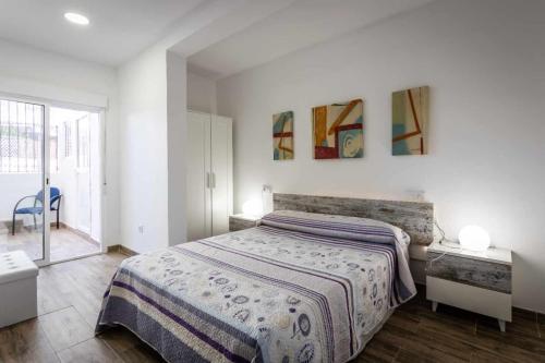 a bedroom with a bed and two paintings on the wall at Nuevo apartamento en bahia de mazarron a estrenar in Murcia