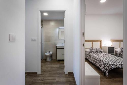 a bedroom with a bed and a bathroom with a sink at Nuevo apartamento en bahia de mazarron a estrenar in Murcia