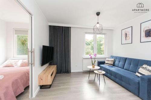 a living room with a blue couch and a bed at Old Town by Apartmore in Gdańsk