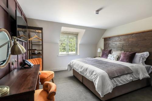 a bedroom with a large bed and a wooden headboard at The Duke on The Test in Romsey