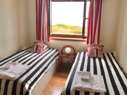 two twin beds in a room with a window at Casa do Mar em Moledo in Moledo