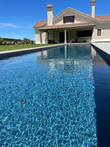 a swimming pool in front of a house at Azores Green Nature in Rabo de Peixe