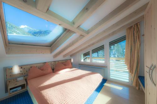 1 dormitorio con 1 cama en una habitación con ventanas en Haus Maryland, en Zermatt