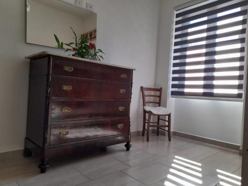 a dresser in a room with a chair and a window at Casa Giampiero in Villaputzu