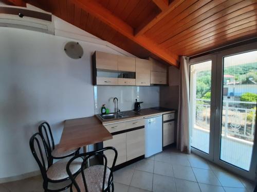 a kitchen with a table and chairs and a window at Zoe's Studios in Parga