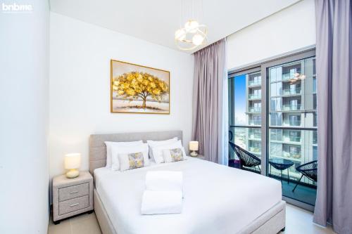 um quarto com uma cama branca e uma grande janela em bnbmehomes - Perfect for Corporate Stays with Great Facilities - 2104 em Dubai