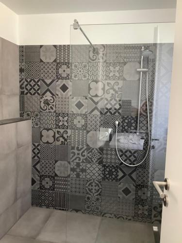 a bathroom with a shower with a tiled wall at Ferienwohnung Gabriel in Kirchentellinsfurt