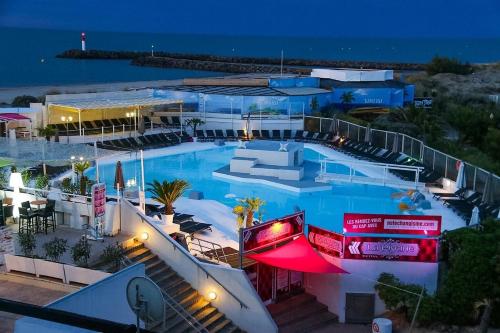 une grande piscine dans un complexe hôtelier la nuit dans l'établissement Cap d'Agde Naturist Exclusive Studio, au Cap d'Agde