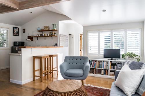 een woonkamer met een bank en een stoel bij Kowhai Cottage & Studio in Raglan