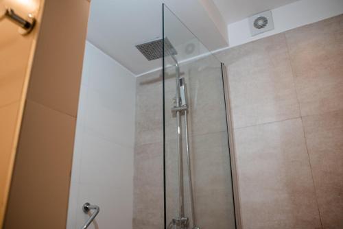 a shower with a glass door in a bathroom at Gran Hotel Dakar in Mendoza