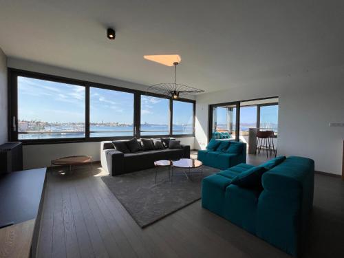 a living room with a blue couch and chairs and windows at The View Luxury Residence with Pool in Zadar