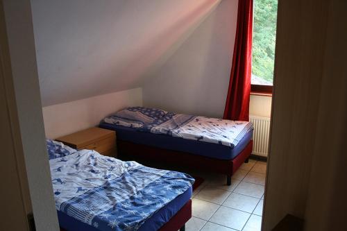 two beds in a small room with a window at Sunshine Apartment 5 in Nidda