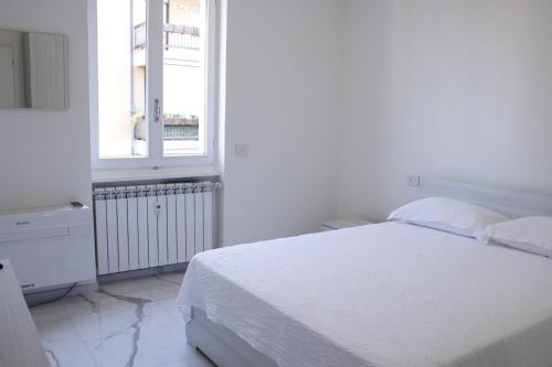 Habitación blanca con cama y ventana en Dreamich - Scavi Romani, en Desenzano del Garda