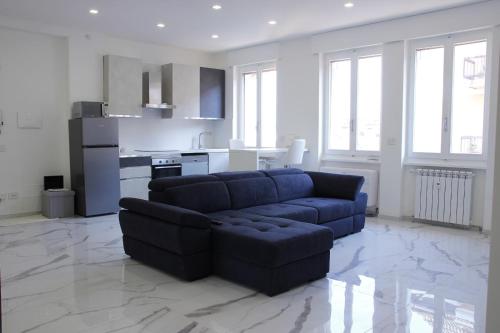 sala de estar con sofá azul y cocina en Dreamich - Scavi Romani, en Desenzano del Garda