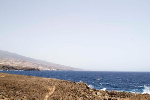 a view of the ocean from a rocky beach at Navy Apartment, El Poris in Arico