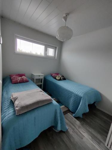 a bedroom with two beds and a window at Hilmantori Apartments by Hiekka Booking in Kalajoki