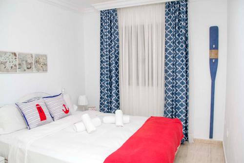 ein Schlafzimmer mit einem weißen Bett mit einer roten Decke in der Unterkunft Navy Apartment, El Poris in Arico