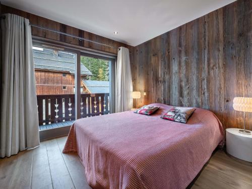 une chambre avec un lit et une grande fenêtre dans l'établissement Appartement spacieux au pied des pistes avec spa, parking et cheminée - FR-1-565-8, à Les Allues