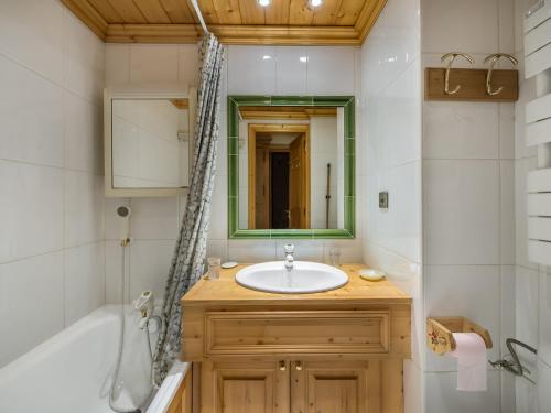 une salle de bain avec un lavabo, une baignoire et un miroir dans l'établissement Appartement Fonctionnel, 4 Pers avec Garage et Terrasse à 100m des Pistes à Méribel - FR-1-565-15, à Les Allues