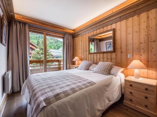 a bedroom with a bed and a large window at Appartement Méribel, 3 pièces, 4 personnes - FR-1-565-19 in Les Allues