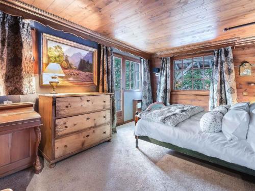 a bedroom with a bed and a wooden ceiling at Chalet chaleureux avec jacuzzi, hammam et salle de jeux à Mussillon - FR-1-565-40 in Les Allues