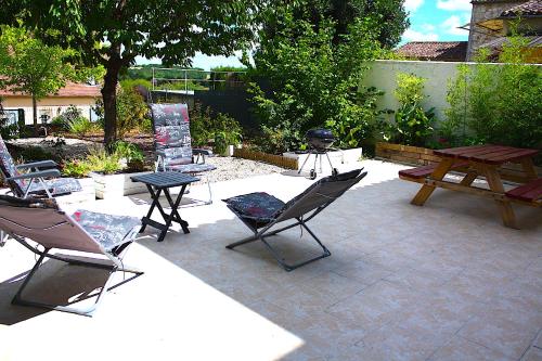 d'une terrasse avec des chaises, une table et une table de pique-nique. dans l'établissement Private Holiday Home in Dordogne, à Beaumont-du-Périgord