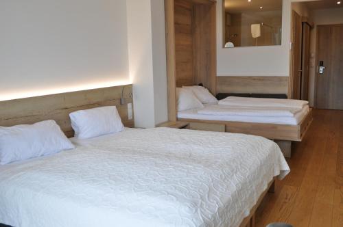a bedroom with two beds and a mirror at Seehotel Herlinde in Podersdorf am See