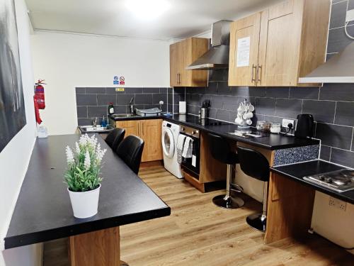 a kitchen with black counter tops and a black counter top at Accommodation Bradford in Bradford