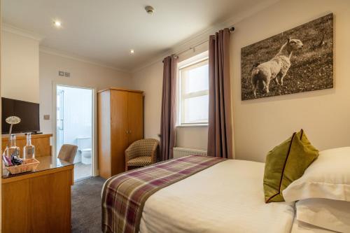 a hotel room with a bed and a picture of a llama at THE INN Hotel Bar and Restaurant in Saint Helier Jersey