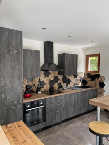 a kitchen with gray cabinets and a stove top oven at CHALET-MICHEL avec SPA in Montperreux