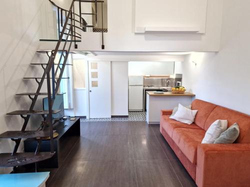 een woonkamer met een oranje bank en een keuken bij Design loft Rosella Home Sorrento in Piano di Sorrento