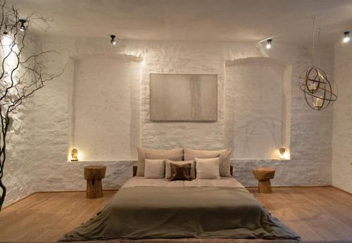 sypialnia z łóżkiem i ścianą z białej cegły w obiekcie n o c t u r n e w Kamieńcu Podolskim