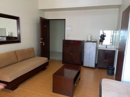 sala de estar con sofá y cocina en 3 Pax Charming Foggy Cold Breeze, Cozy Gardenville Hotel, en Baguio