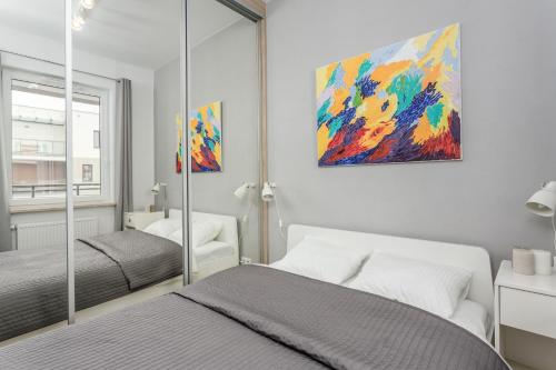 a bedroom with two beds and a painting on the wall at Chill Apartments Warsaw Airport in Warsaw