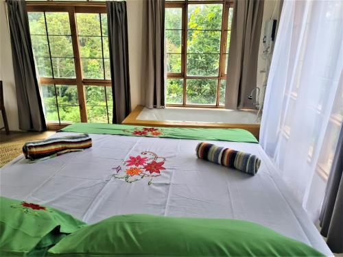 a bed with a white blanket with flowers on it at Holiday cottage by the river, Arusha in Arusha