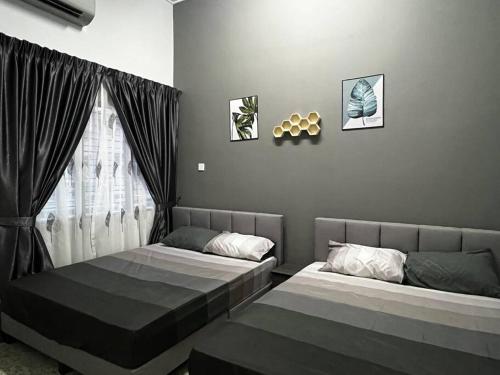 a bedroom with two beds and a window at You&Me Corner Lot Homestay 17PAX in Port Dickson