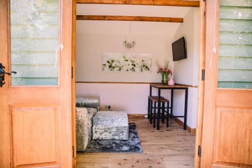 a door leading into a living room with a couch and a table at Snowdrop Lodge, Walcot Hall Estate in Alkborough