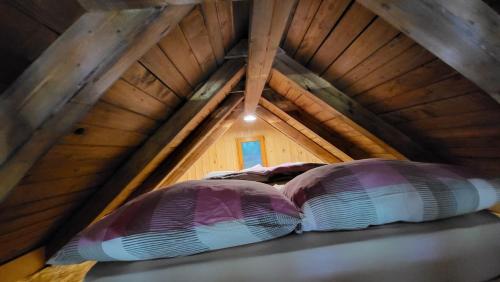 two pillows sitting on a shelf in a attic at Glamping Fikfak in Bled