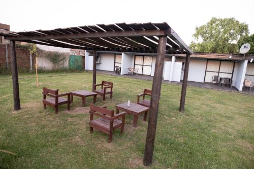 a group of benches sitting under a pavilion at Aramis in Chascomús